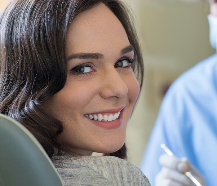 Woman with beautiful smile after dental crown placement