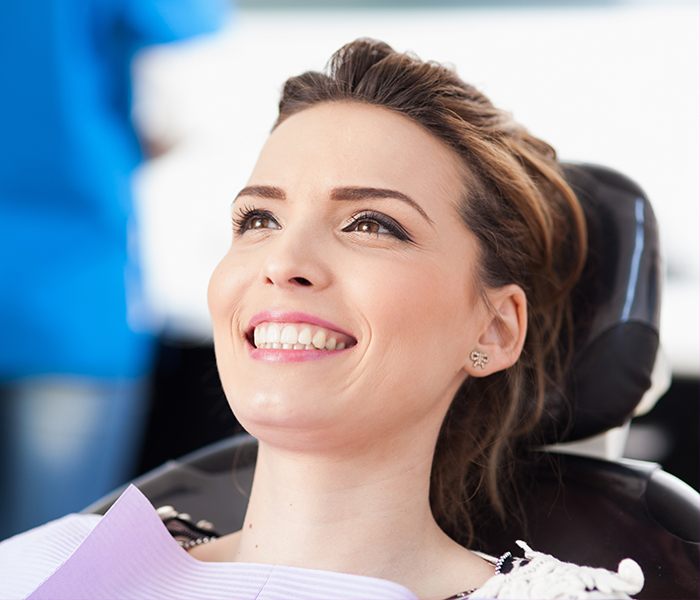 Smiling woman in modern dental office exam room