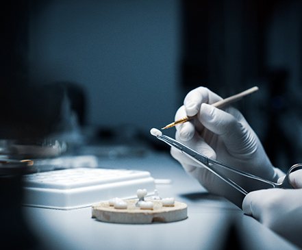 A dental technician working on dental crowns