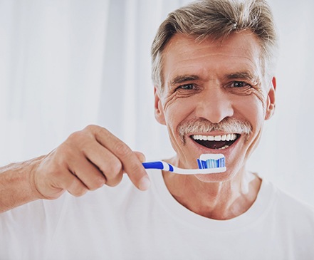 man brushing his teeth 