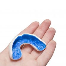blue mouthguard in a person’s hand