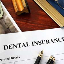 Dental insurance paperwork on desk with supplies