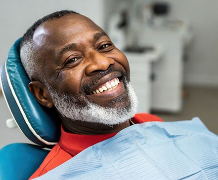 Man smiling while sitting in dental chair