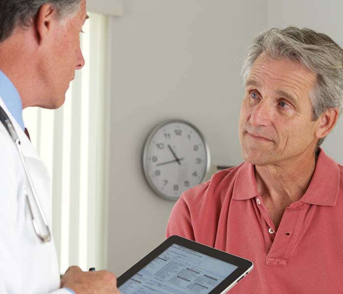 Older man listening to an emergency dentist in Spring