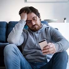 Man holding phone preparing to report a dental emergency