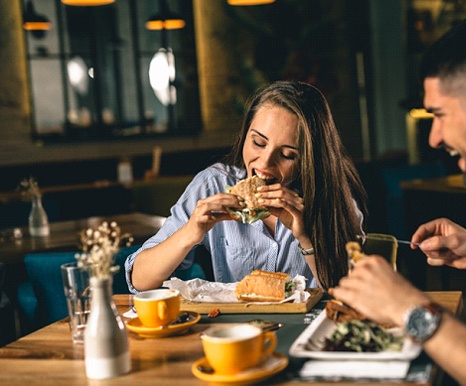 Woman eating lunch with her friend during Invisalign treatment
