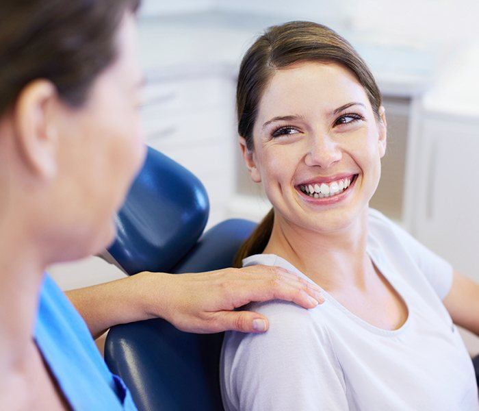 Woman smiling at dentist during dental checkup