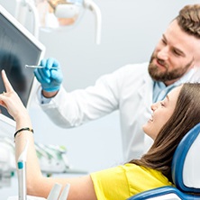 Spring dentist showing patient treatment options on screen