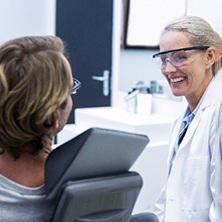 Spring dentist talking to patient about cost of veneers