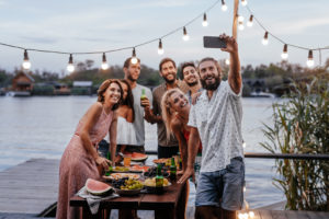 Group of young people taking selfie at outdoor party