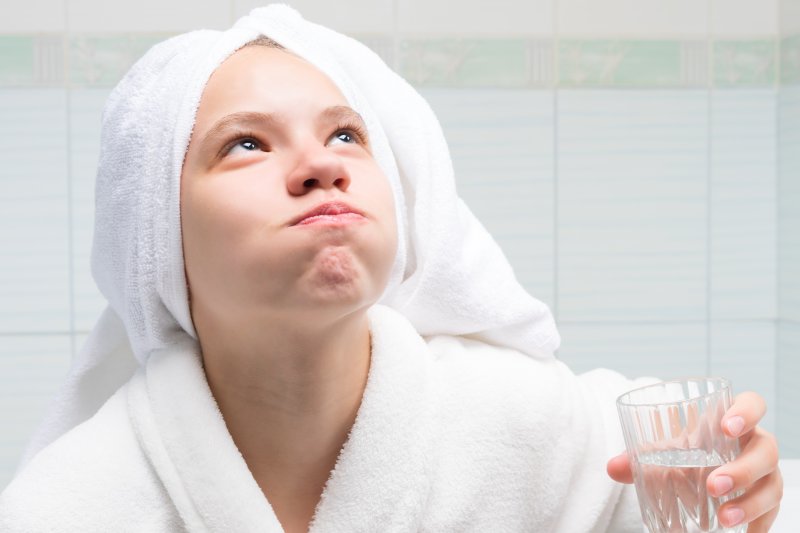 Person rinsing their mouth with water