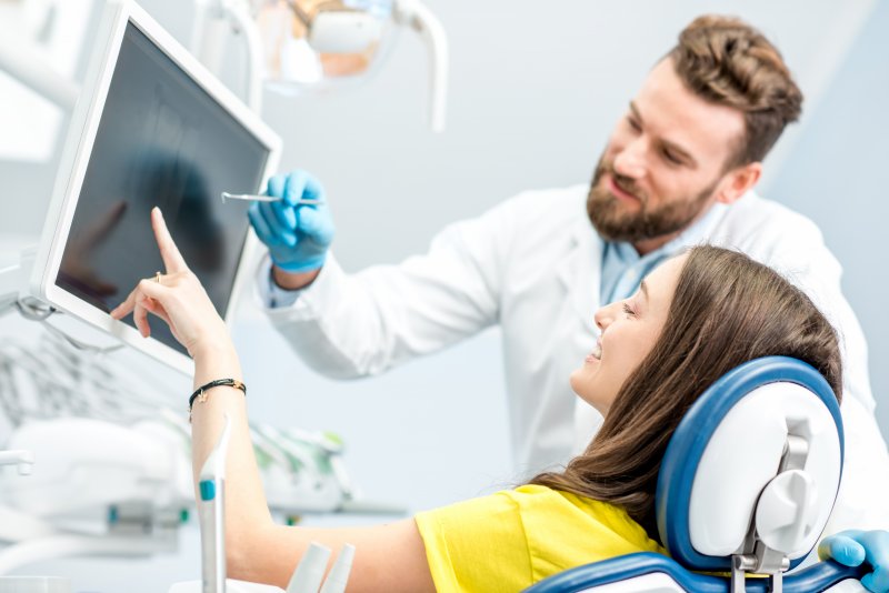 dentist showing smiling patient X-rays