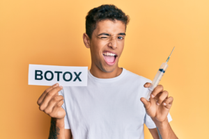 a man smiling and holding a BOTOX sign